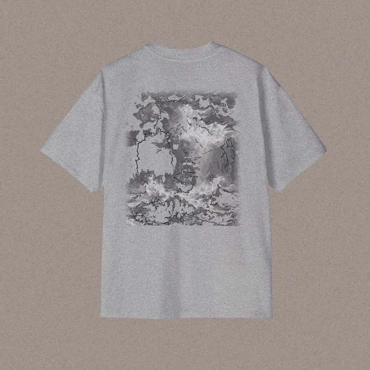 Back of an oversized t-shirt in grey, showing the ABYSS design: a tall-masted ship heeled over against rising swell and closing storm, printed in monochrome greys.